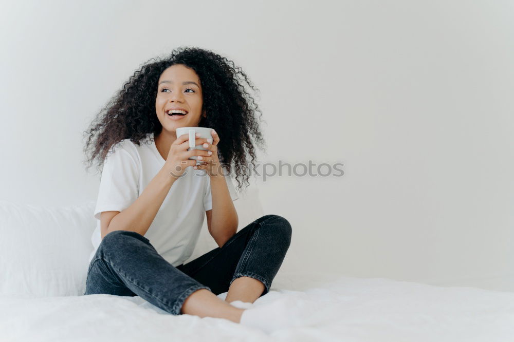 Similar – close up of a pretty black woman with curly hair smiling and covering with sheets on bed looking away