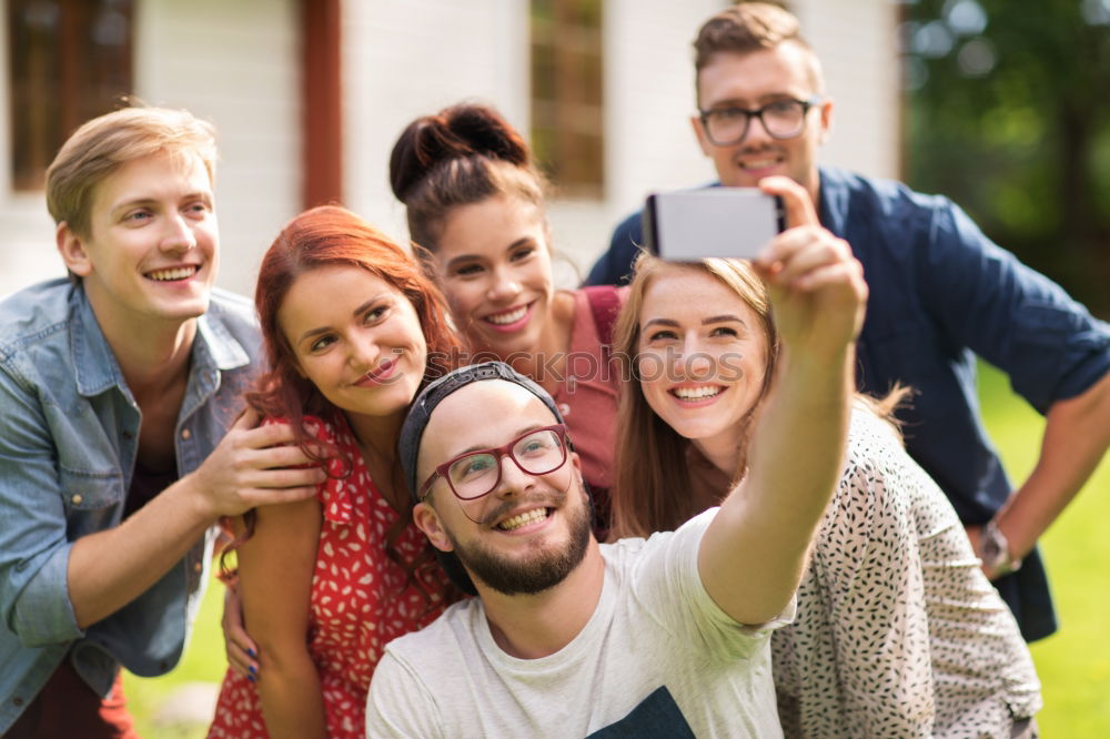 Similar – Multiracial group of friends taking selfie in a urban park