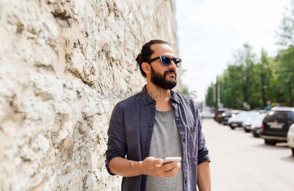 Similar – Young bearded man, model of fashion, in urban background wearing casual clothes while leaning on a wall and looking aside