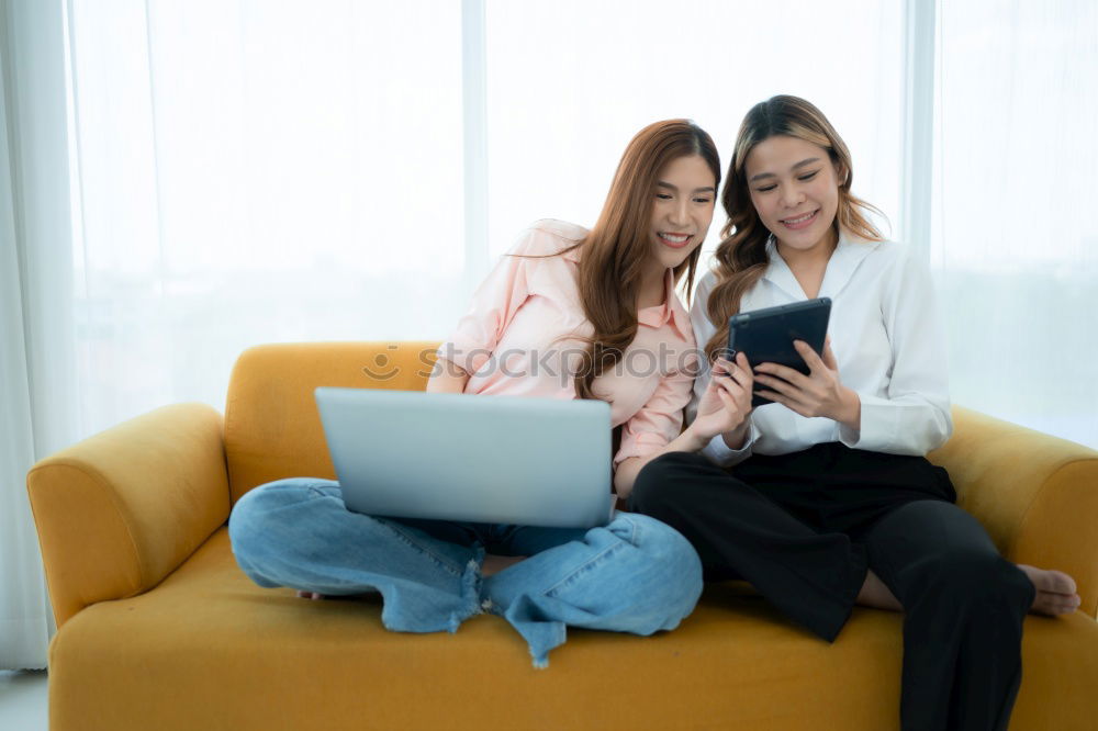 Similar – Image, Stock Photo Overhead photograph of two beautiful young women at home sitting on sofa while using a tablet PC computer and smiling