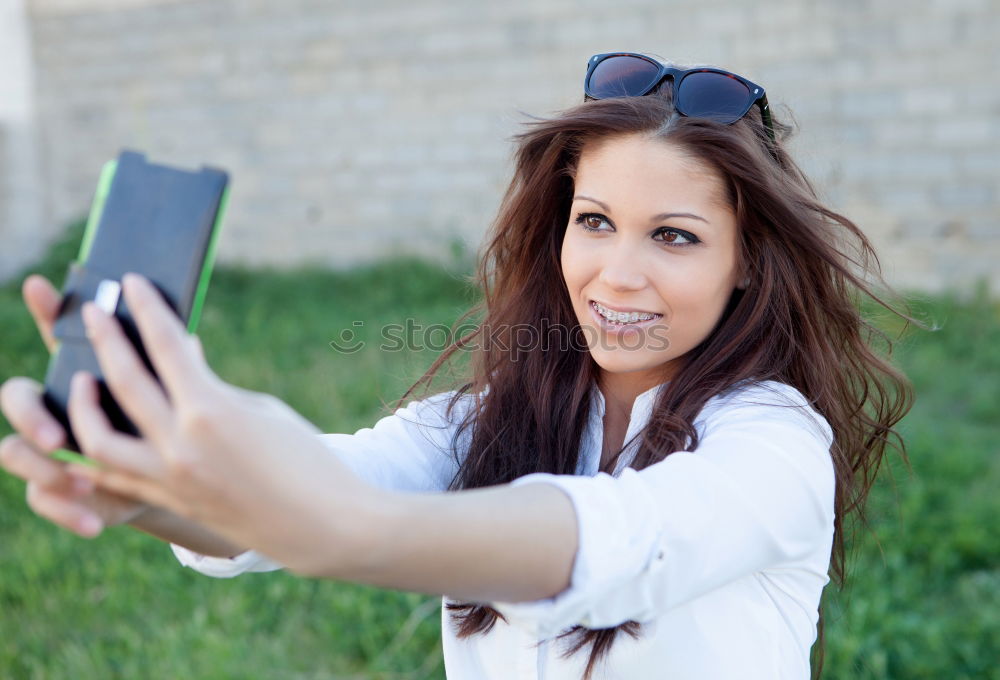 Similar – Young happy woman with green jacket taking selfie with her smartphone on the beach at sunset