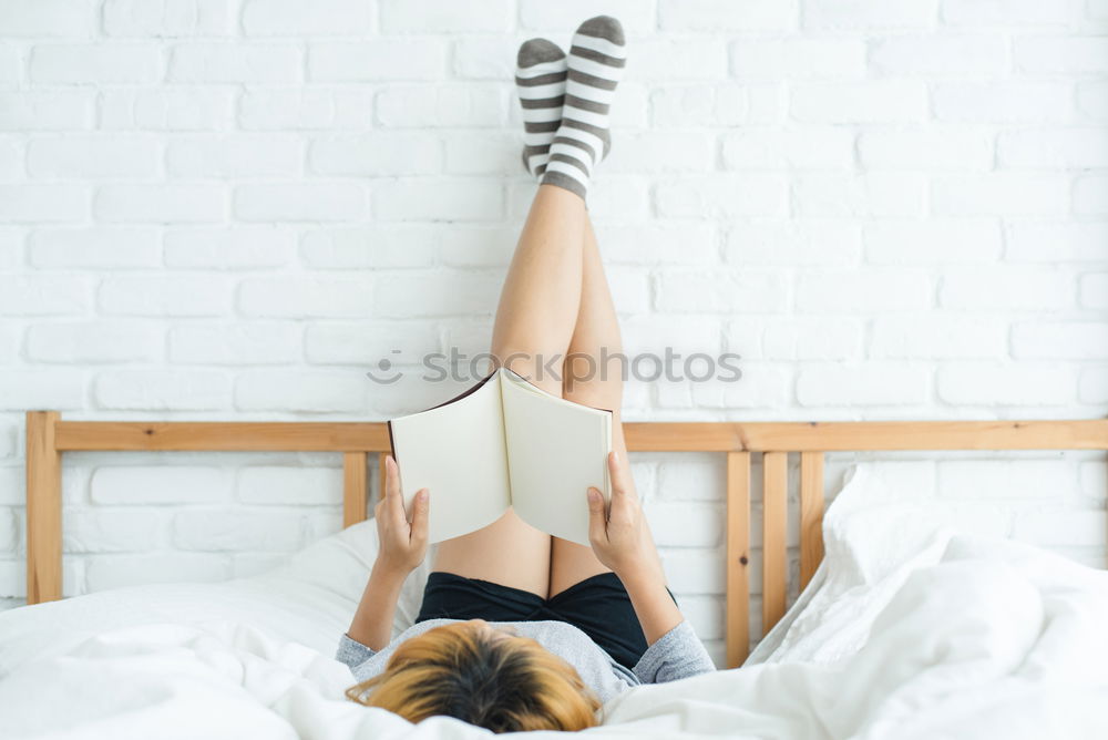 Similar – Weiches Foto von Frauenbeinen auf dem Bett mit einem alten Buch neben ihr