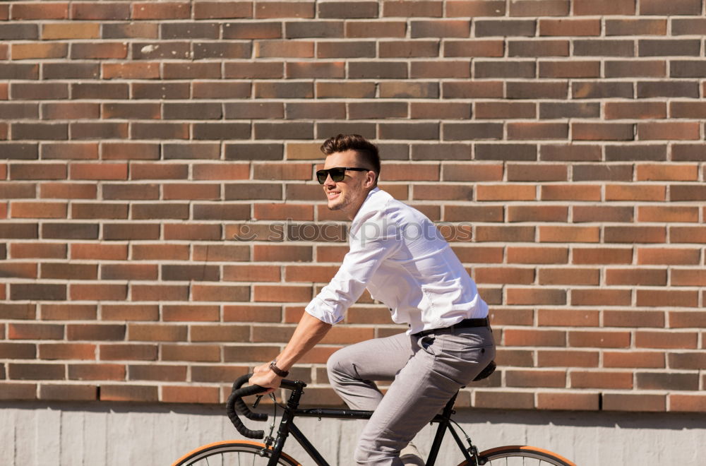 Sportlicher Mann mit Fahrrad beim Telefonieren