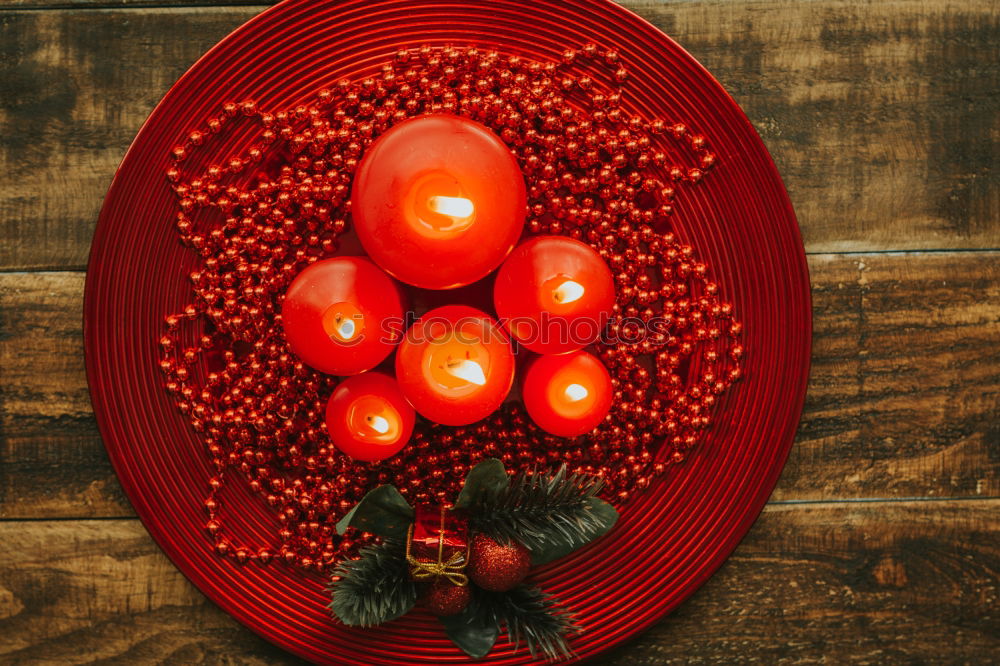 Lighted candles with red colored pearls around