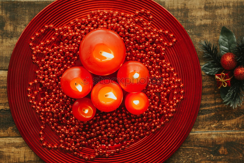 Similar – Lighted candles with red colored pearls around