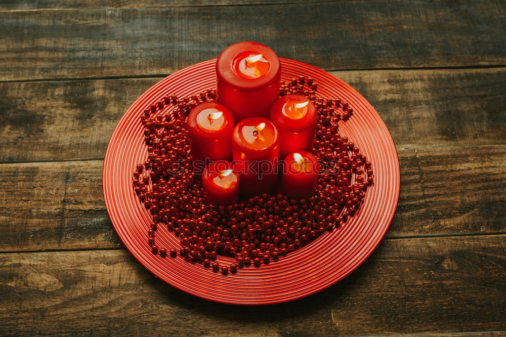 Similar – Lighted candles with red colored pearls around