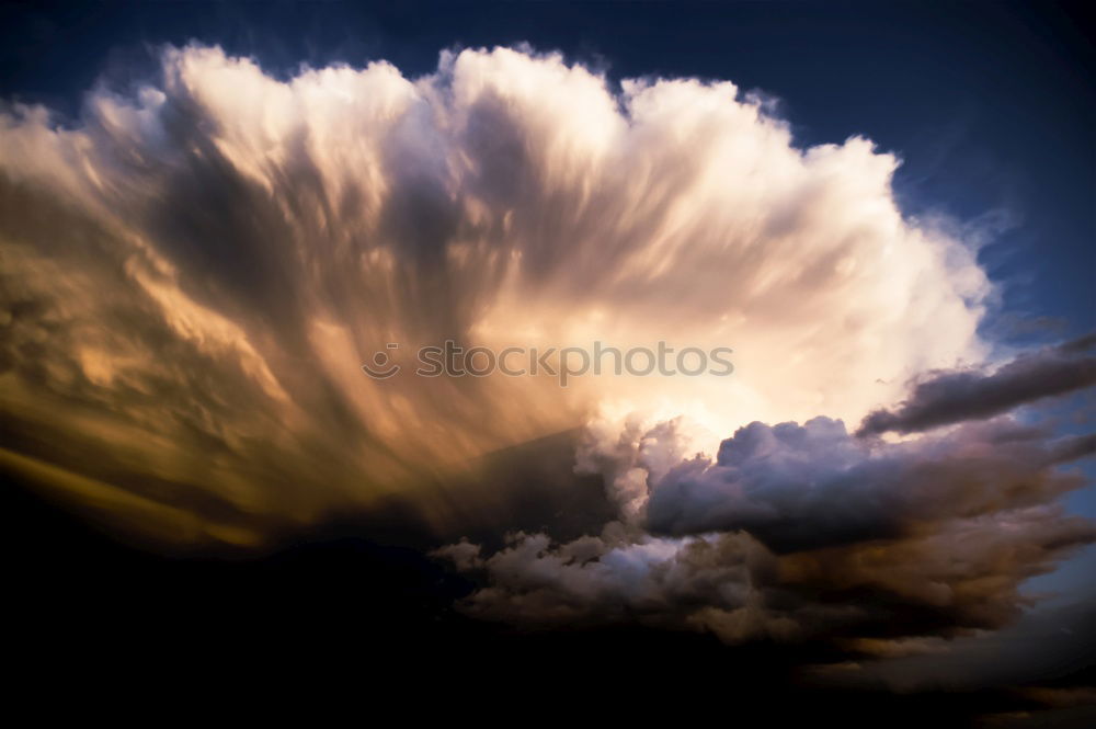 Sky colors, black clouds with gold yellow sun shimmering over the city