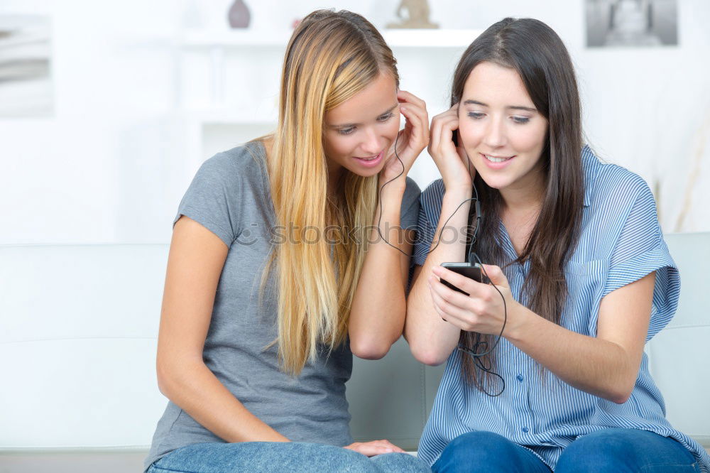 Similar – Image, Stock Photo Young women using mobile phones watching music clip, texting, messaging. Teenagers using the smartphones, sitting on sofa at home. Using technology devices. Girls wearing summer clothing