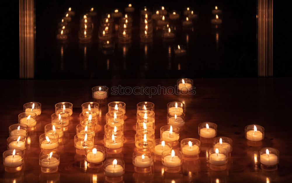 Similar – Image, Stock Photo many church candles with varying degrees of burn stuck in the sand in the dark. selective focus. dripping wax from one candle.