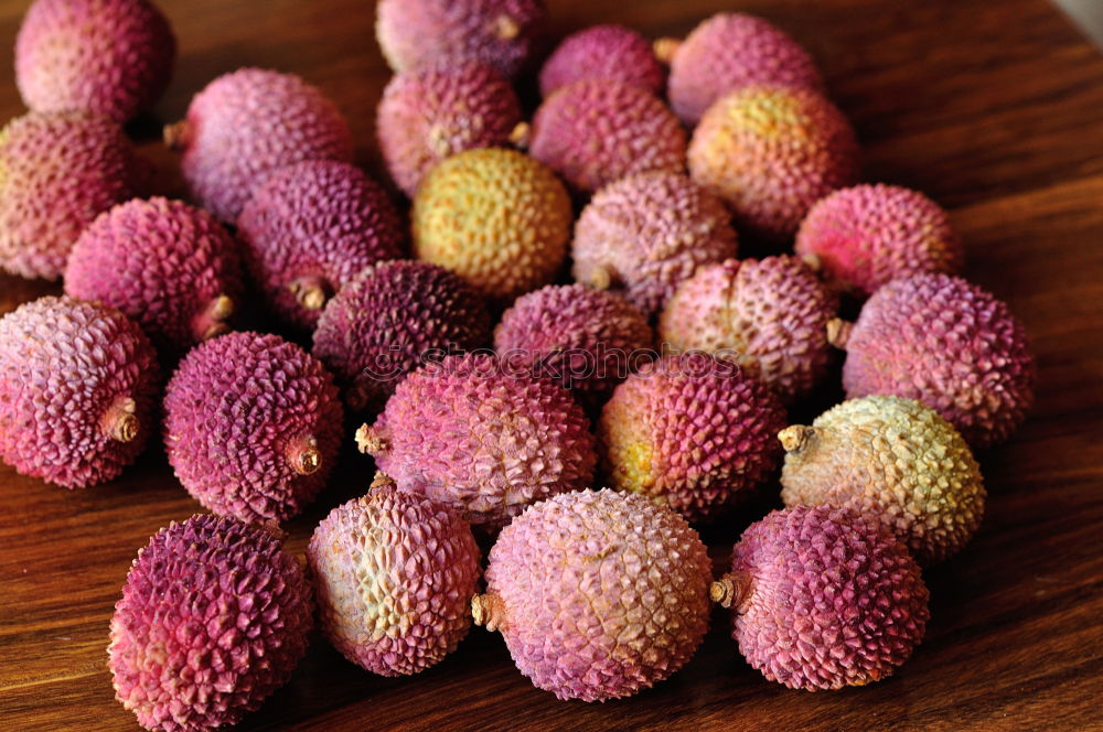 fresh tropical rambutan fruits over rustic wood table