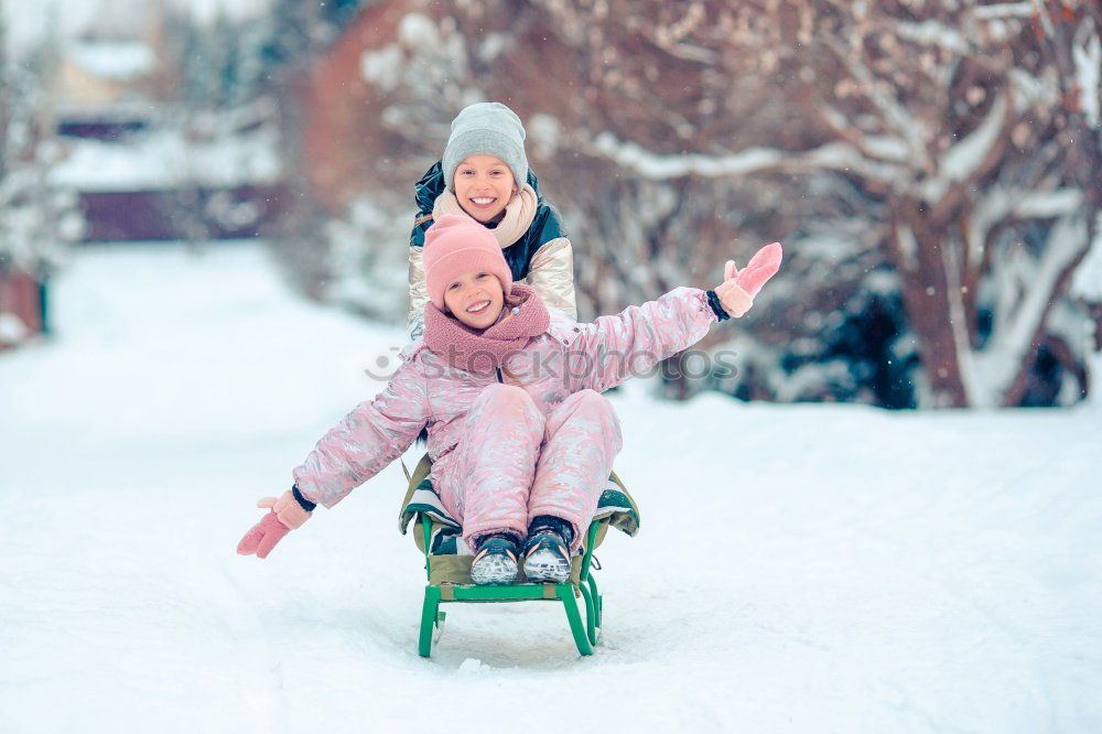 Similar – Teenage girl pulling sled with her little sister through forest