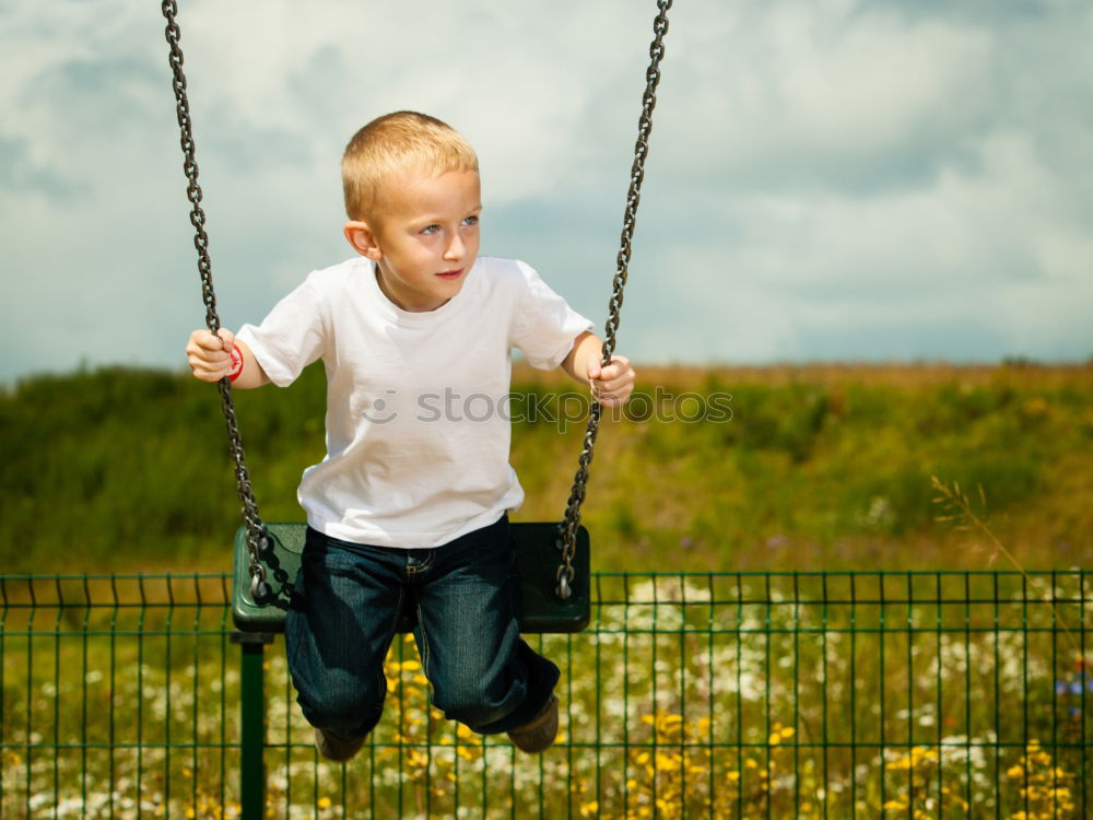 Child climbing on the playground in autumn