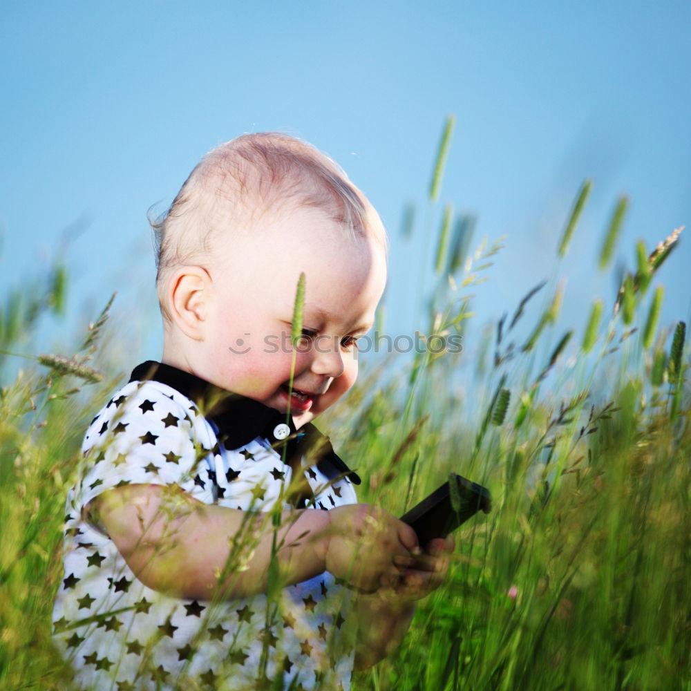 Similar – Image, Stock Photo Little baby girl watching a book with pictures