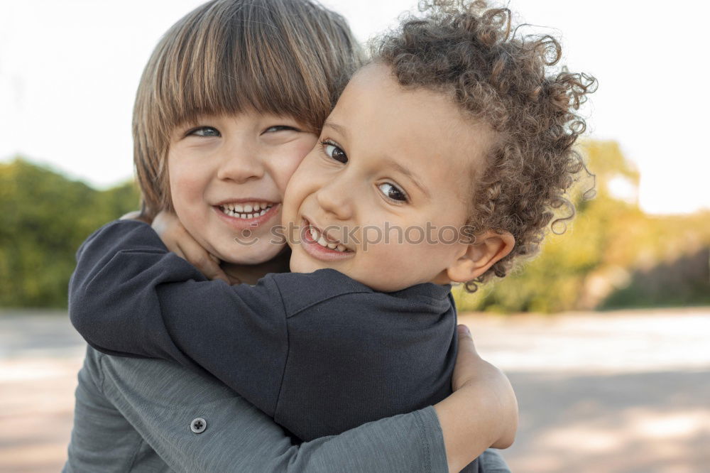 Similar – Two adorable young brothers outdoors in winter wrapped up warmly against the chill weather with the older boy cuddling his toddler sibling on his lap