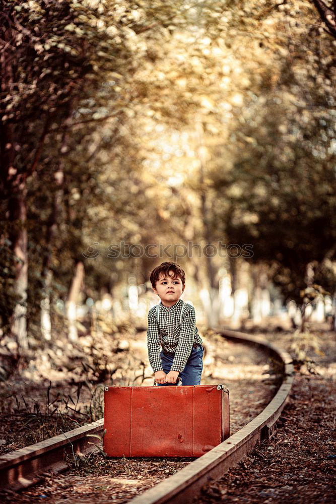 Similar – boy on the train tracks with suitcase