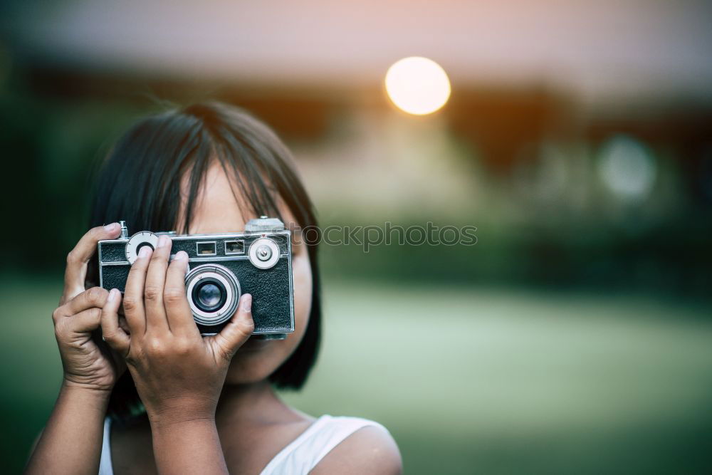 Similar – Smiling young woman using a camera to take photo at the park.