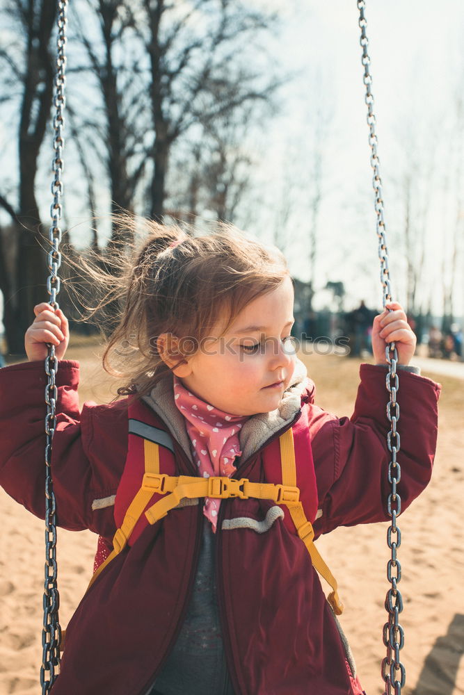 Little caucasian girl having fun on slide on playground