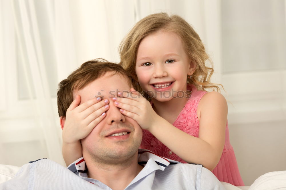 Similar – Father and daughter playing at home. Little girl closing dads eyes with hands and laughing. Family fun together