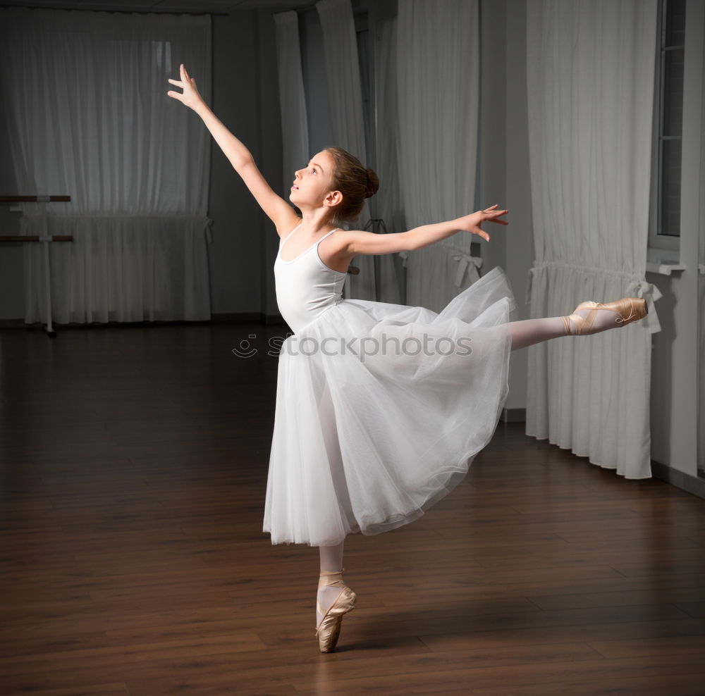 Hübsche junge Ballerina tanzt klassisches Ballett an rustikaler Wand