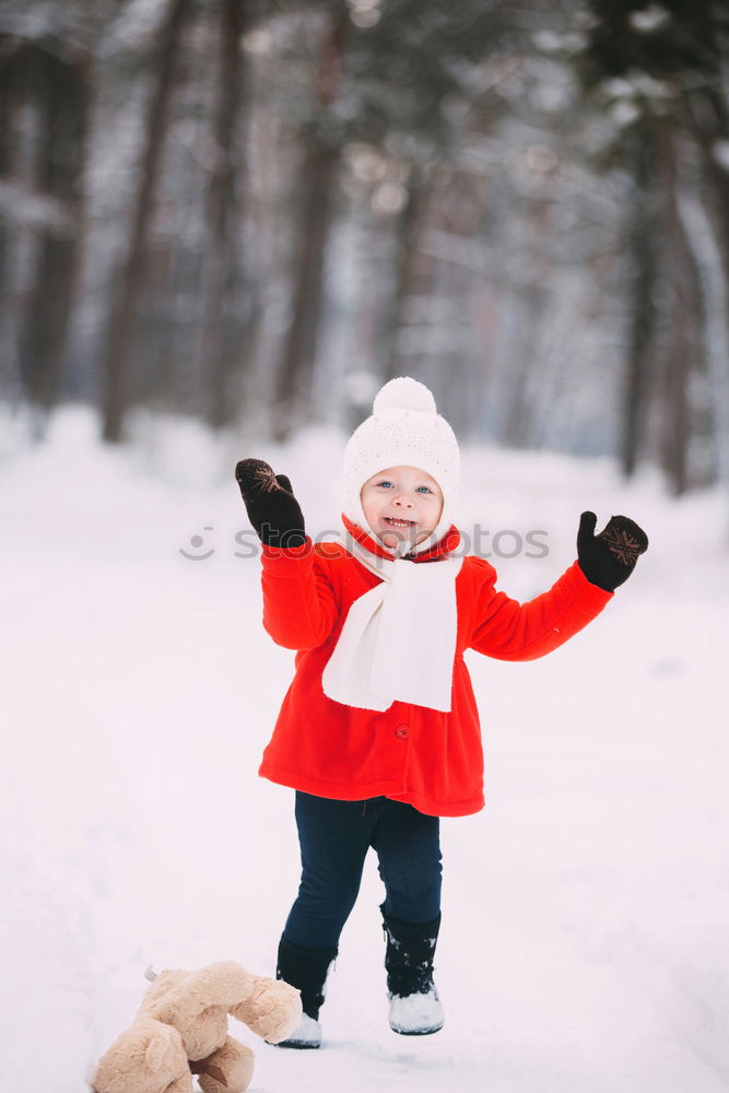 Similar – Mother is playing with her little daughter outdoors on wintery day. Woman is throwing snow on her child. Family spending time together enjoying wintertime. Woman is wearing red coat and wool cap, toddler is wearing dark blue snowsuit