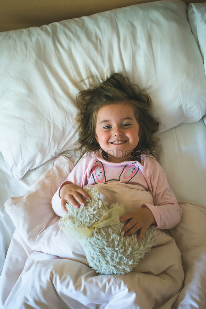 Similar – Kleines Mädchen liegt in einem Bett mit Teddybär am Morgen. Glücklicher Morgen. Schlafenszeit. Wochenendmorgen