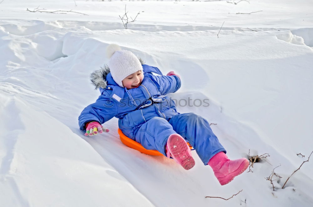 Similar – Little girl enjoying winter removing snow from a bench