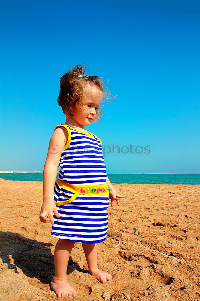 Similar – little girl stands on beach in a special swimsuit for children who can not swim. child in swimsuit, which he kept afloat