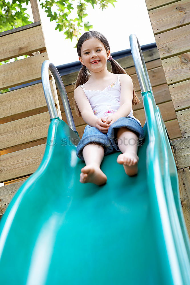 Similar – Cute caucasian siblings sitting on slide on playground