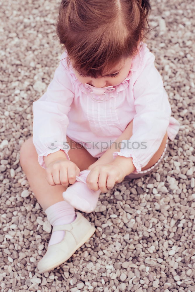 Little girl putting on her socks