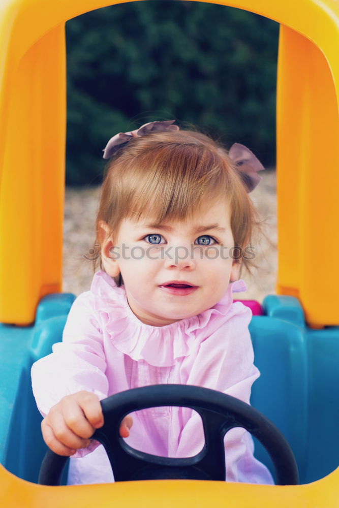 Young girl playing to driving a toy car