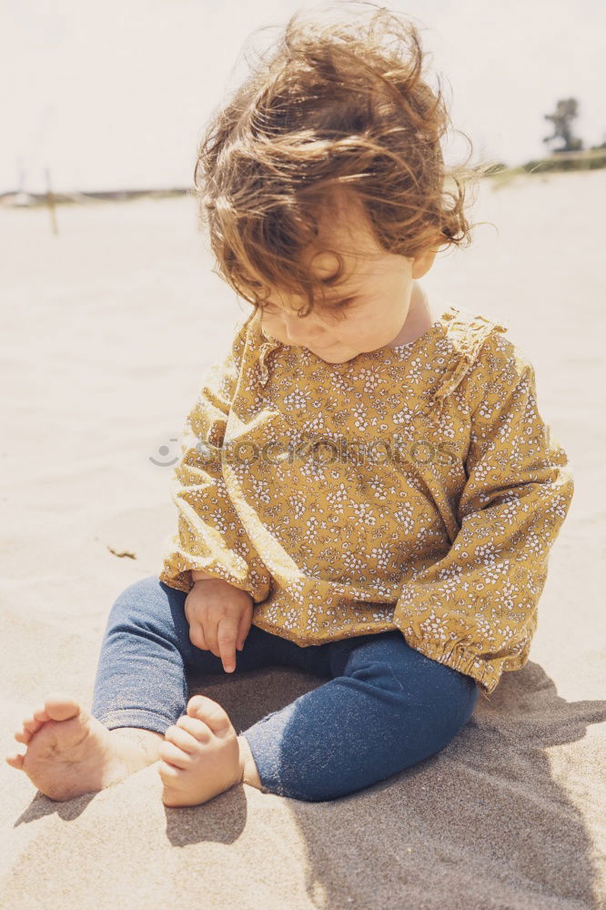 Similar – Child sitting by the sea with a view of a jetty