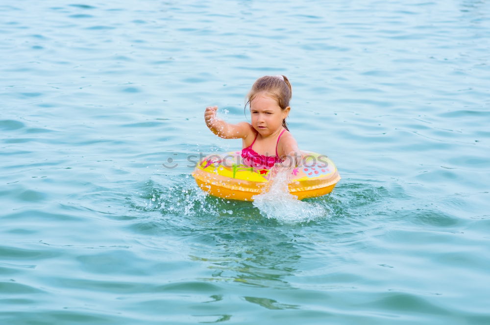 Similar – Image, Stock Photo Happy little girl floating with a ring in the water