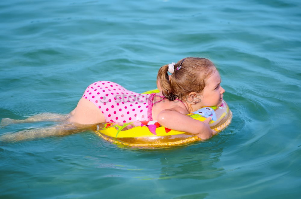 Similar – Image, Stock Photo Happy little girl floating with a ring in the water