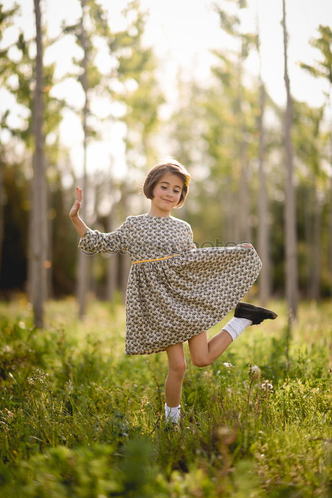 Kleines Mädchen im Naturfeld mit schönem Kleid