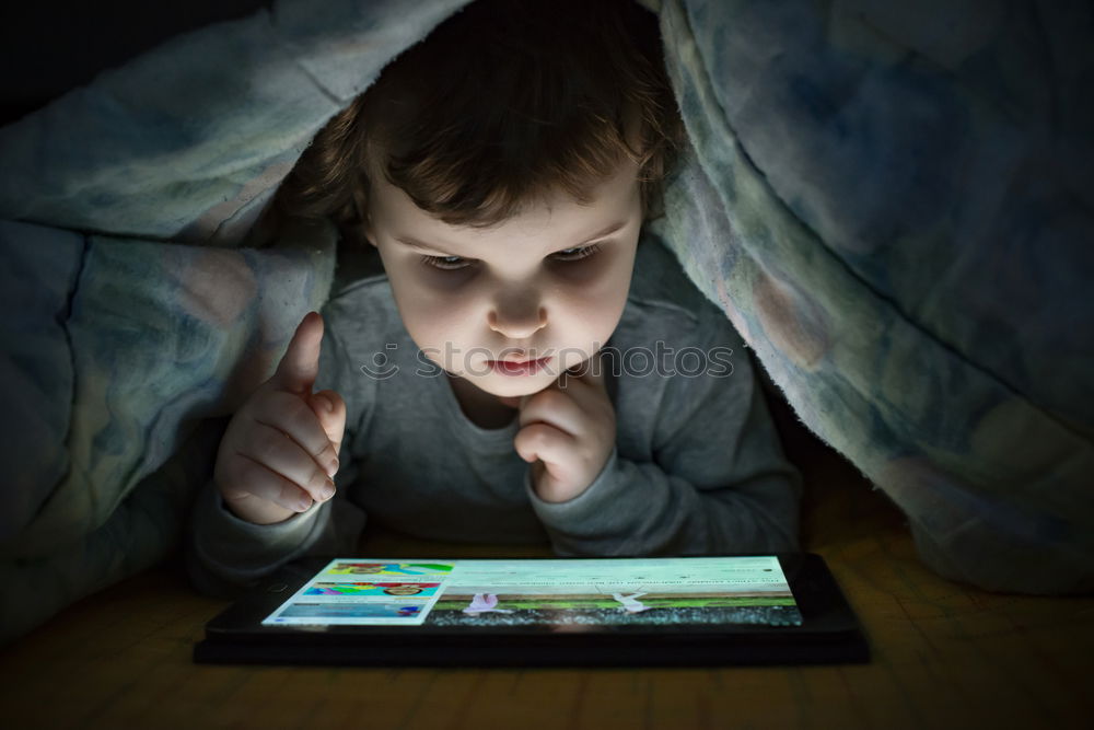 Similar – Image, Stock Photo Little boy sitting in his seat during a flight playing contentedly with a tablet computer in an airplane watched by his mother