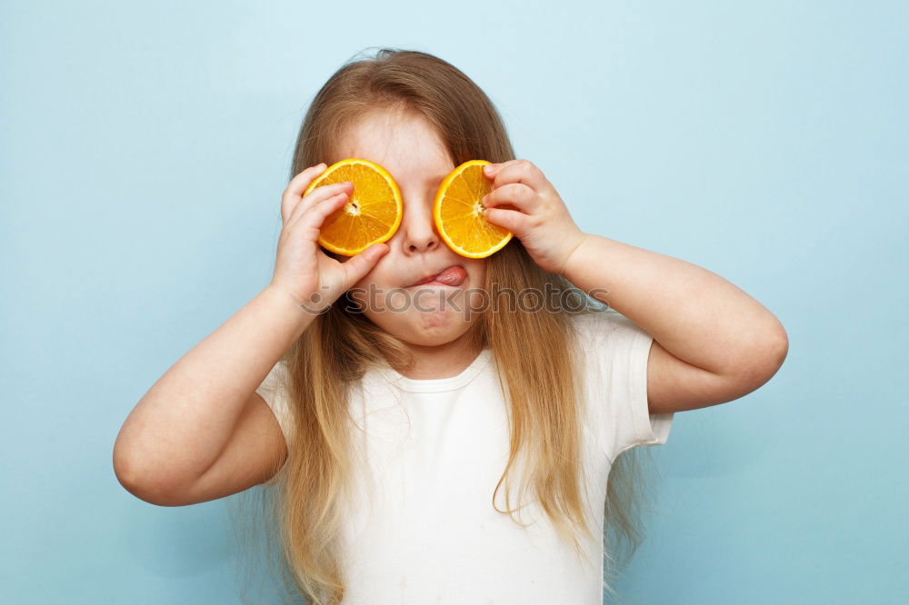 Image, Stock Photo baby eating an orange on blue background