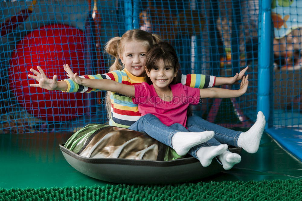 Similar – Cute caucasian siblings sitting on slide on playground