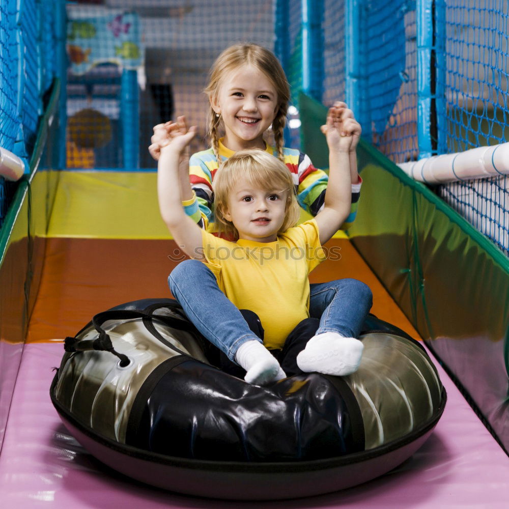 Similar – Cute caucasian siblings sitting on slide on playground