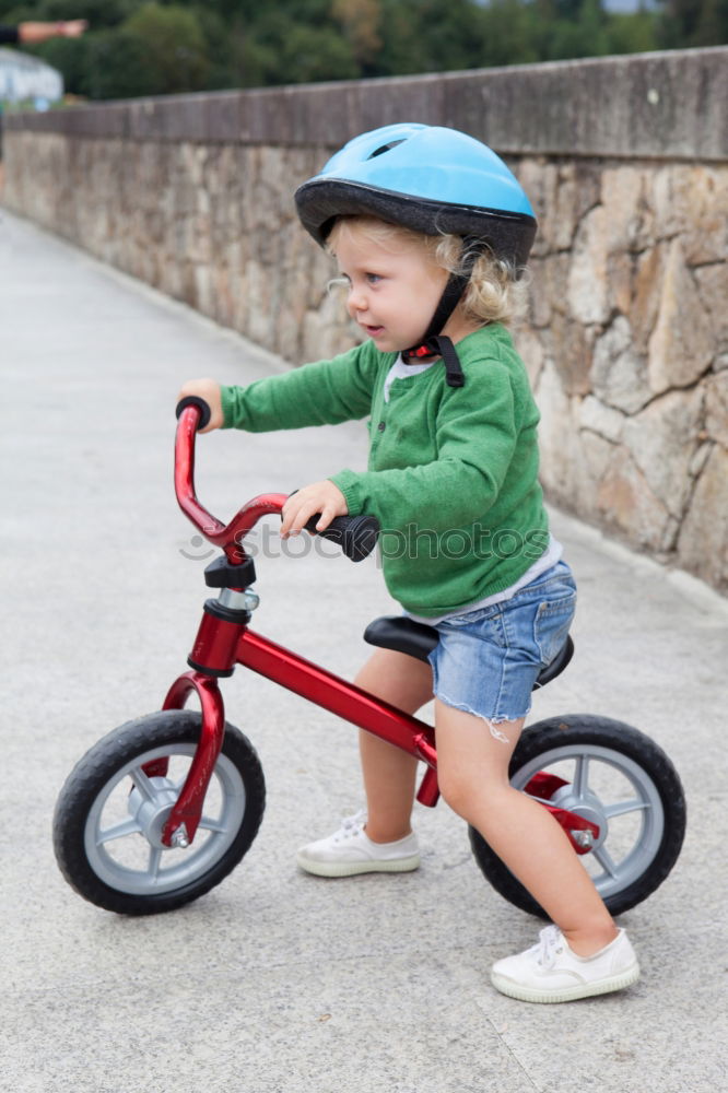 Similar – Image, Stock Photo Little kid riding his bicycle on city street