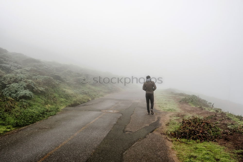 Similar – Man standing on foggy road