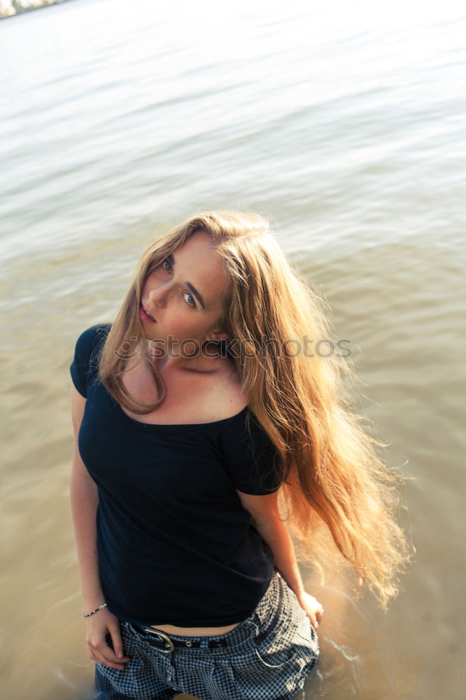 Similar – Young woman sitting on the banks of the Rhine with her feet in the water