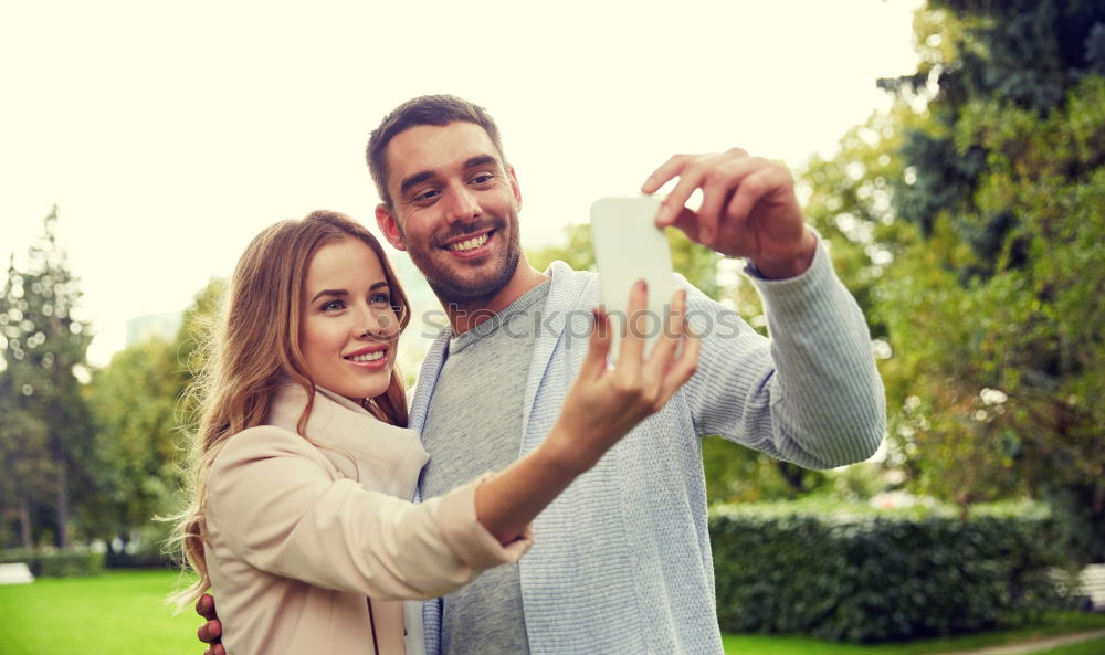 Similar – Young couple taking selfie photo with smartphone outdoors