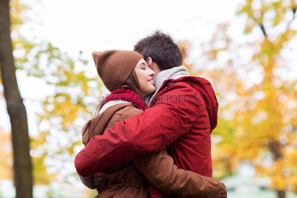 Young couple embracing and having hot beverage outdoors