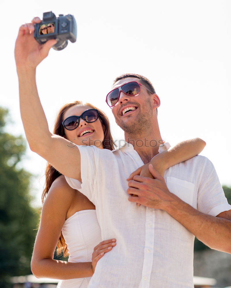 Similar – Happy young man and woman in fashionable sunglasses taking cellphone selfie on background of defocused blue sea. Vacation photos