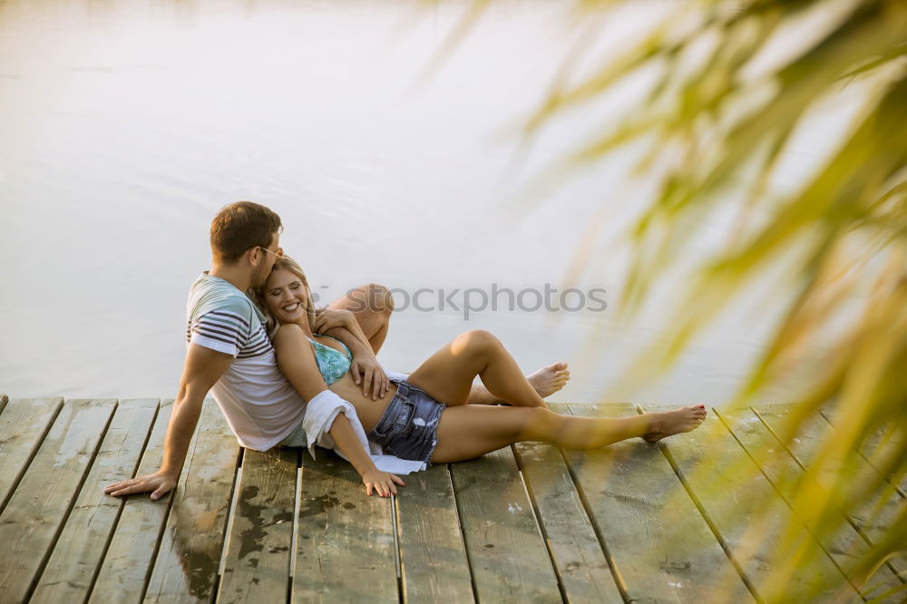 Similar – Couple lying at lake together