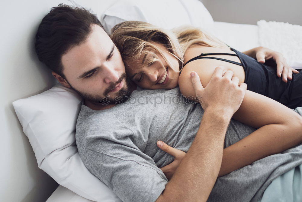 Couple laying on couch watching TV together