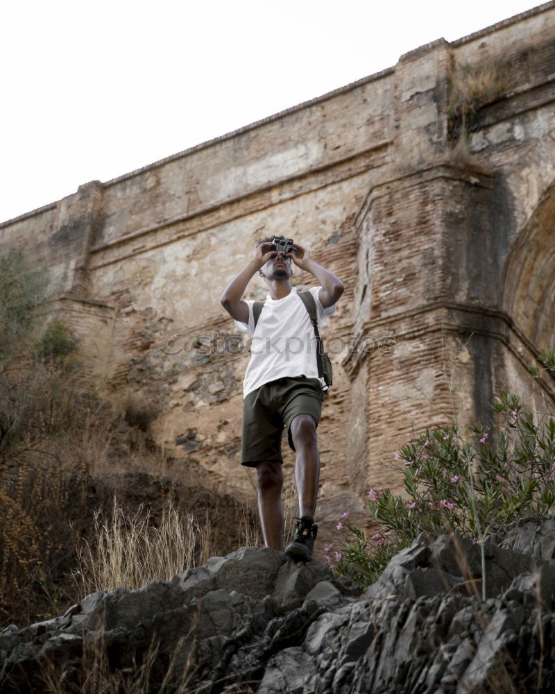 Man with camera walking in a rural road