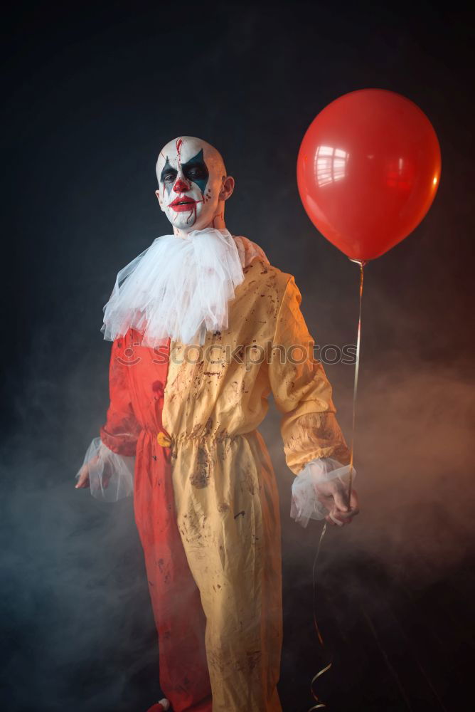 Similar – boy dressed as a clown on black background