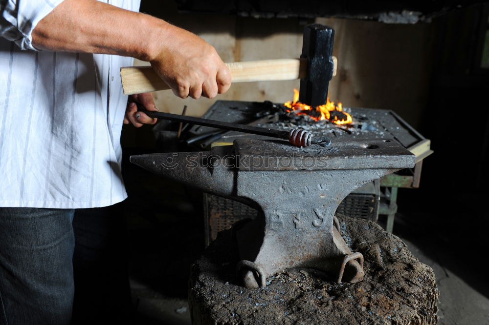 Similar – Blacksmith forges iron on anvil