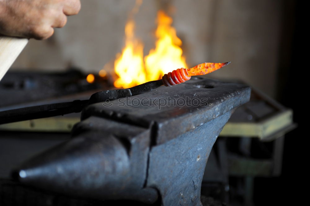 Similar – Blacksmith forges iron on anvil